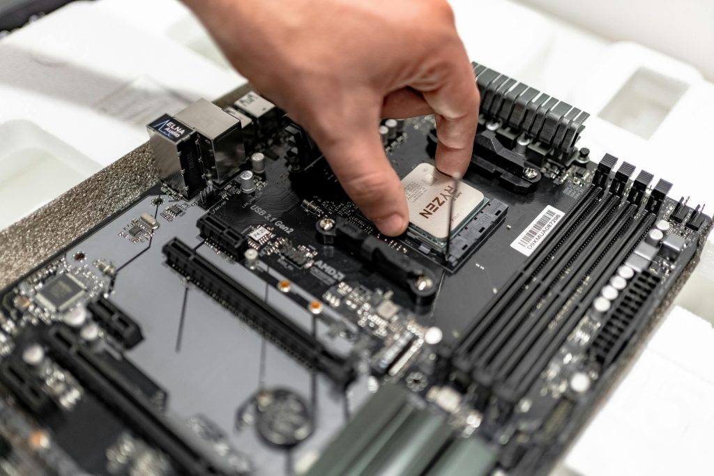 Hand installing AMD Ryzen CPU on a motherboard during a custom PC build
