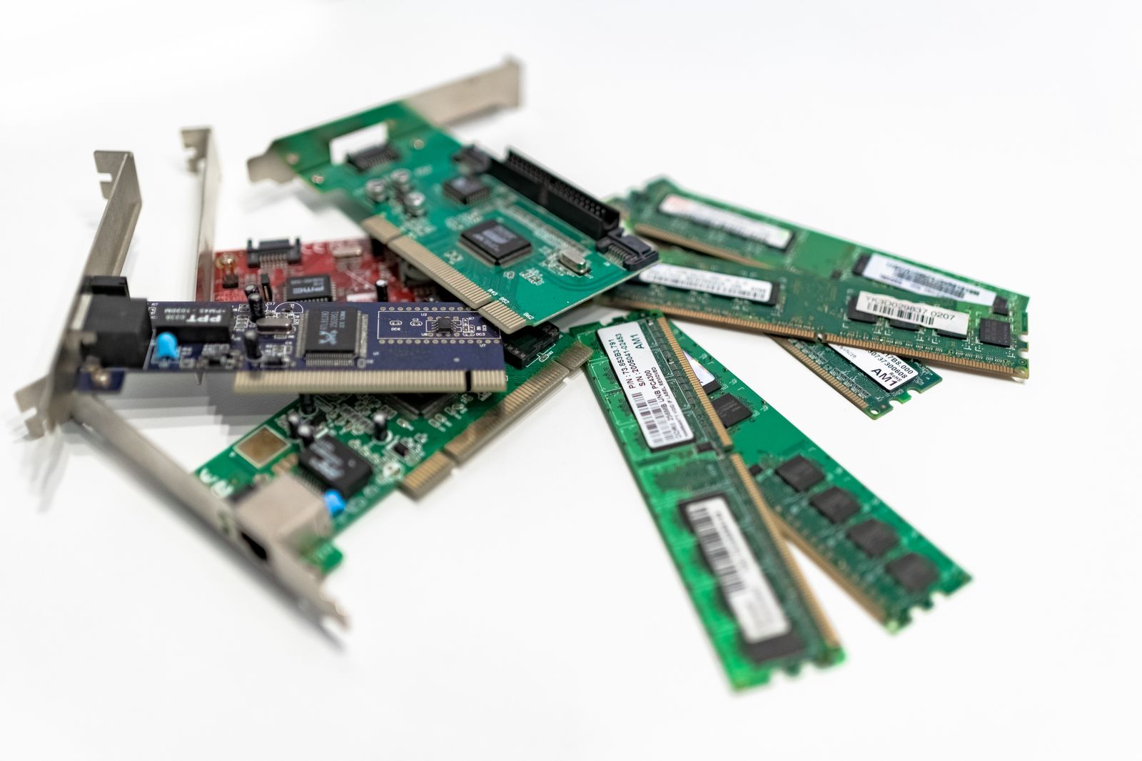 Computer RAM sticks and PCI cards on a white surface