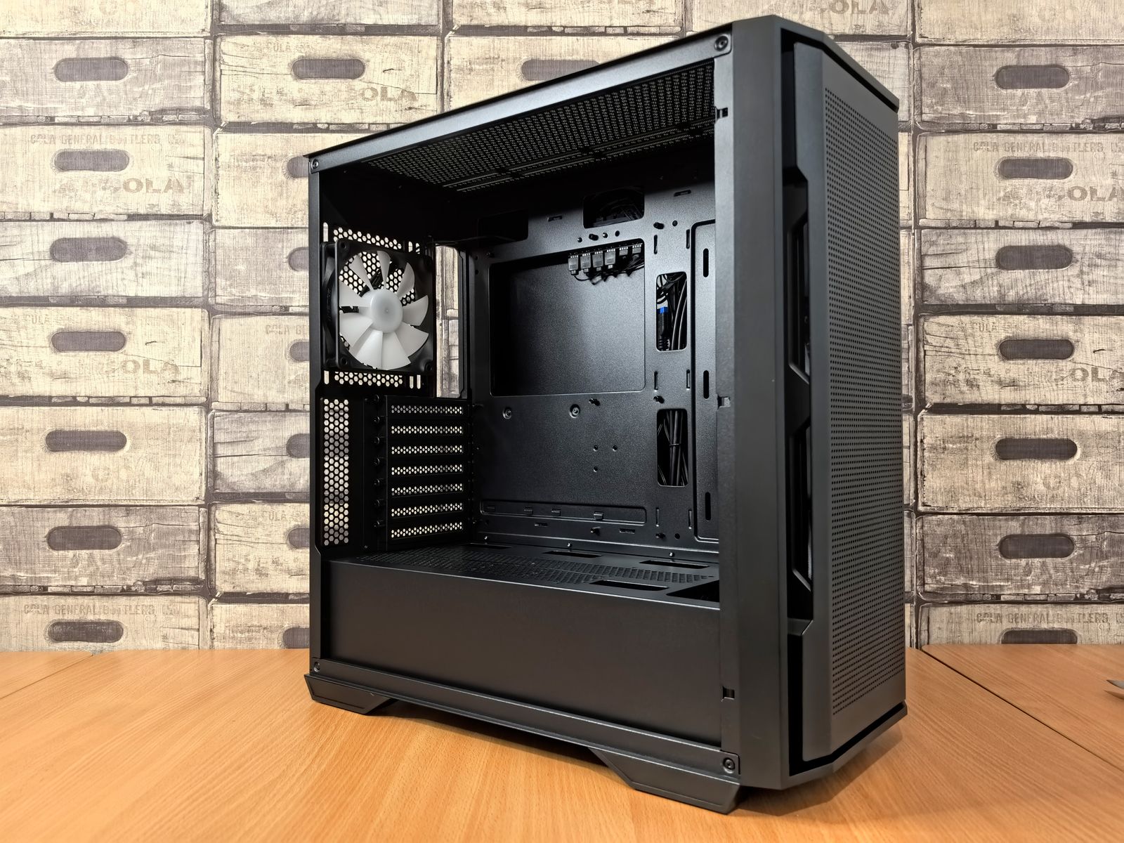 Open black computer case with a fan on top