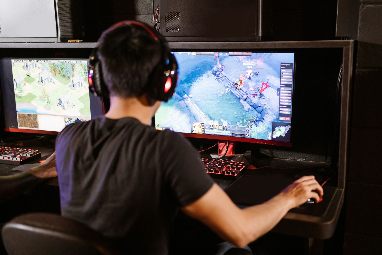 Man gaming on dual monitors with headphones