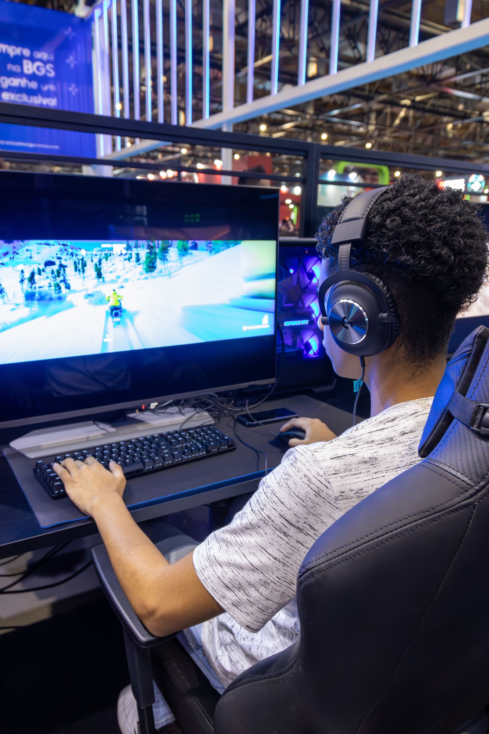 Teen playing video games on a desktop computer with headphones