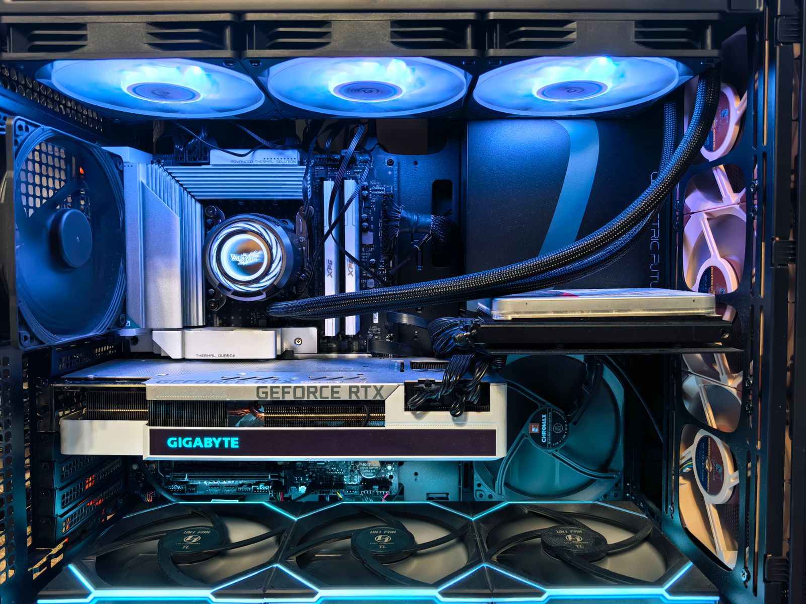 Gaming PC interior showing GPU, RGB fans, and liquid cooling tubing