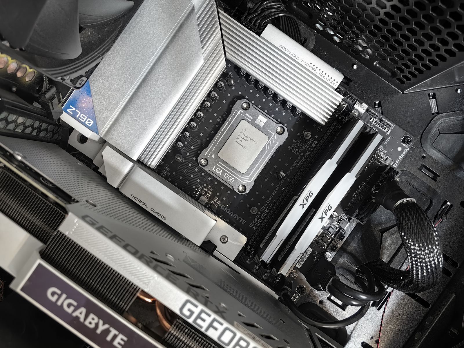 Motherboard with CPU installed and GPU mounted below, cable management visible